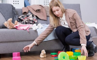 young mum clearing away child's toys