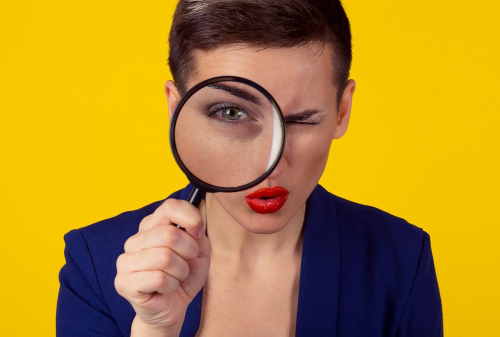 Woman looking through magnifying glass