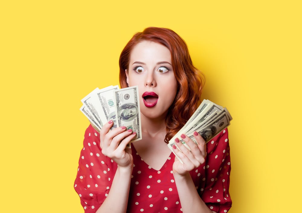 Woman looking at money in surprise