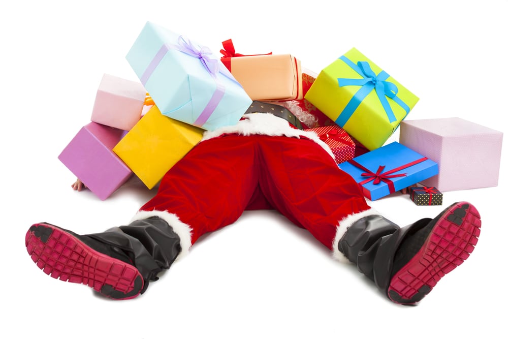 Santa lying on back covered in presents