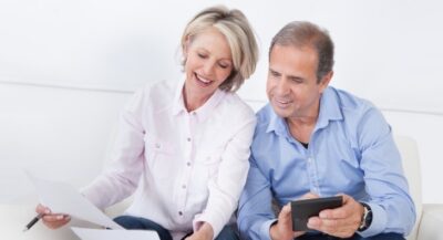 Happy middle aged couple working out their financial situation