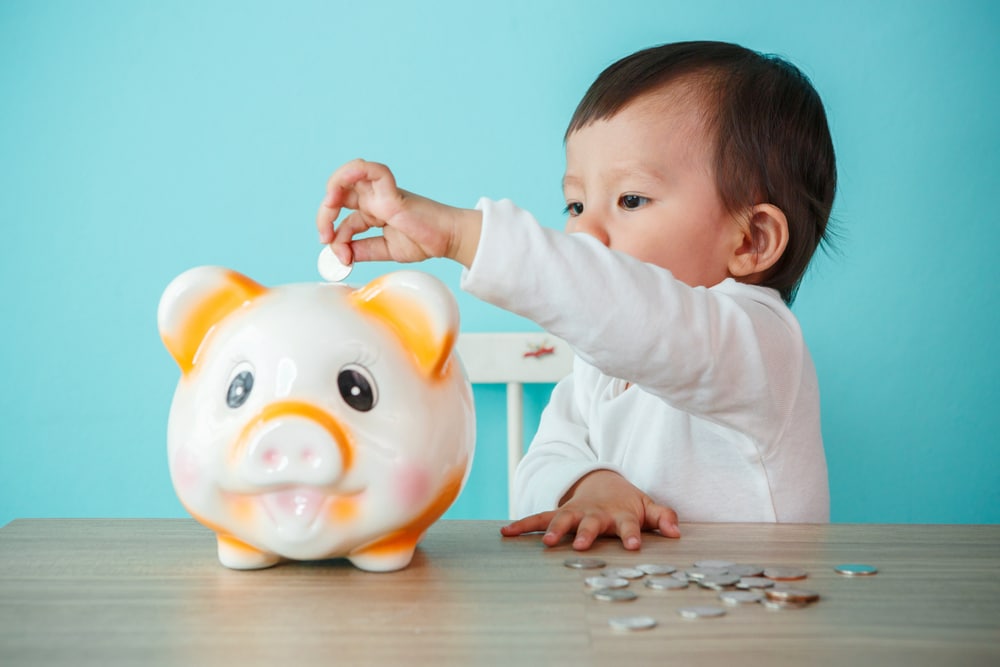 Baby putting money in piggybank