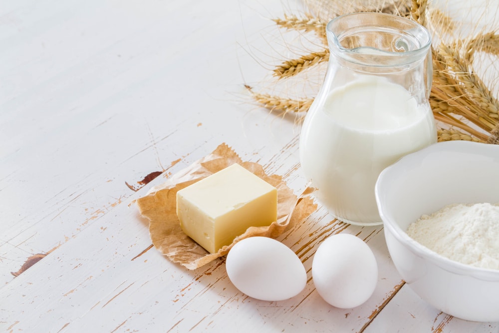 Jug of milk surrounded by other baking ingredients