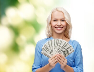 Woman holding fan of dollars made investing in s&p 500 index