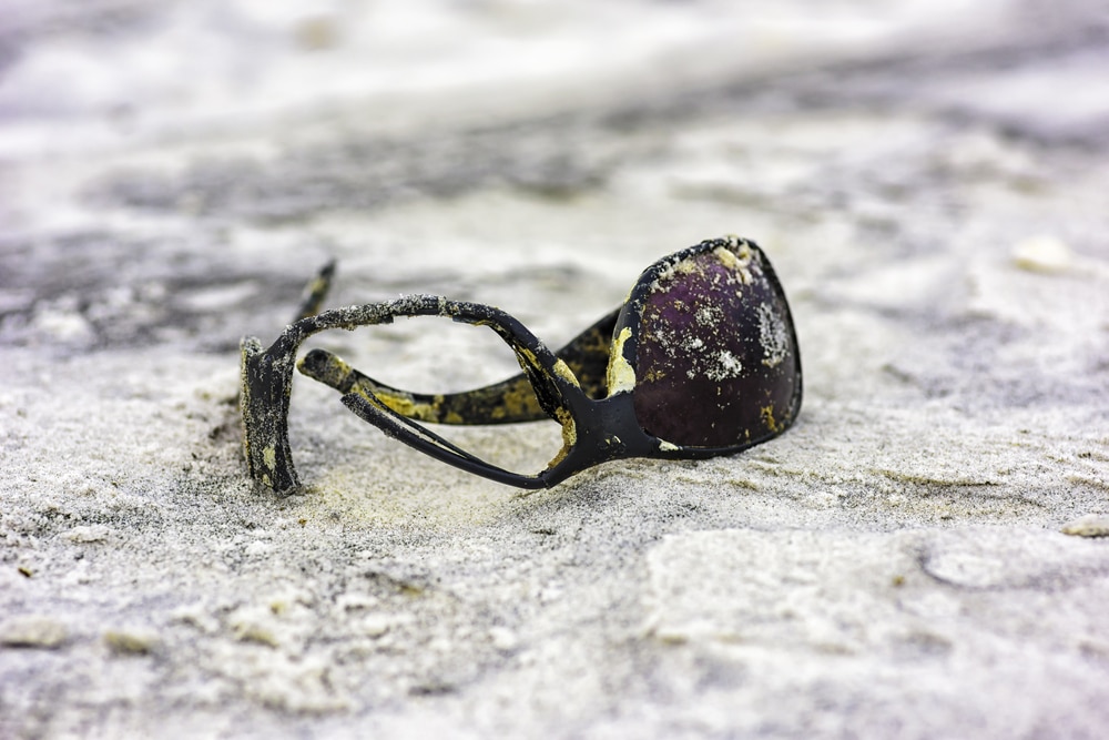 Broken sunglasses in the sand