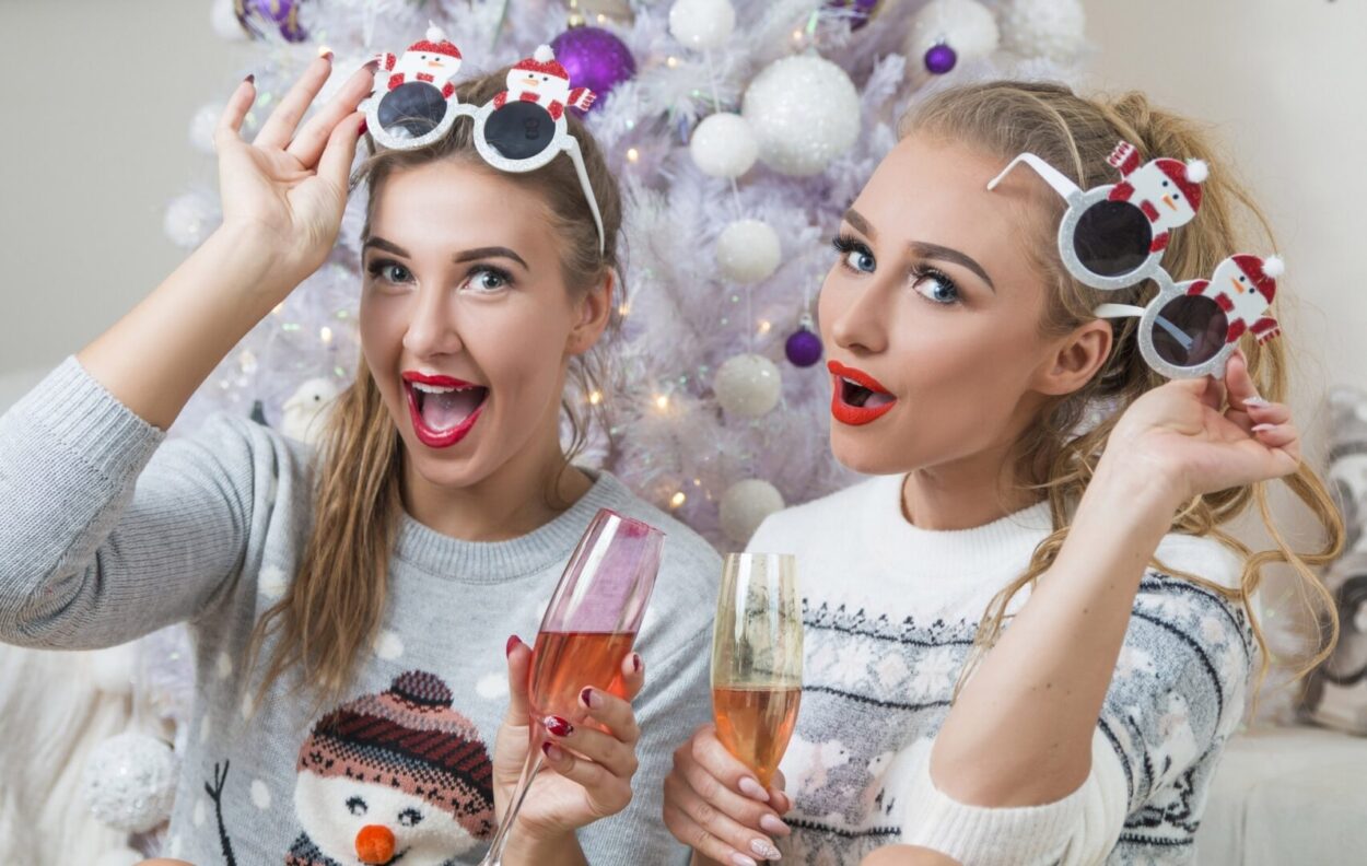 Women wearing silly christmas jumpers and glasses