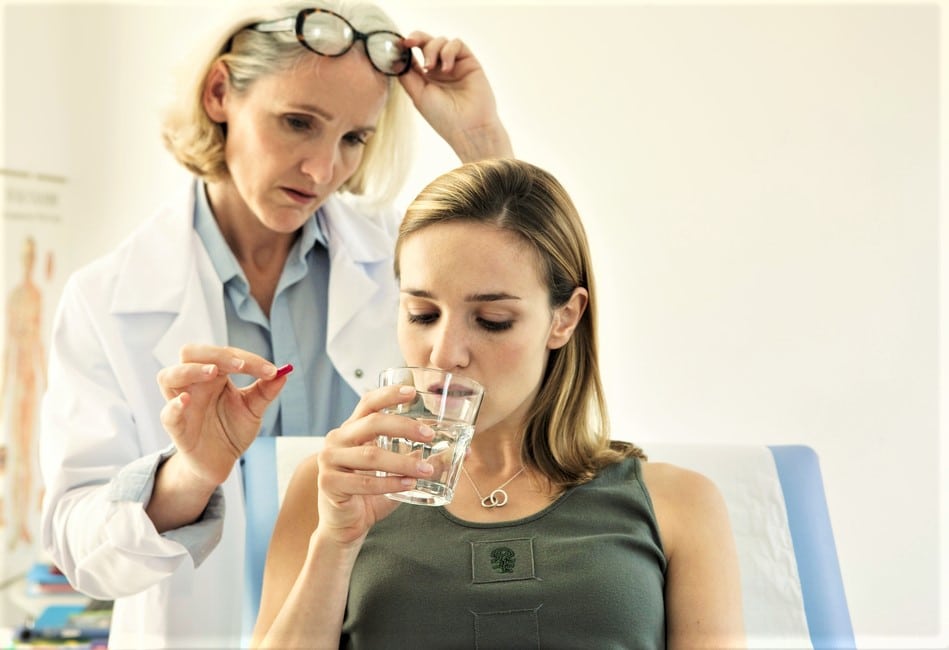 Docotor giving young woman medication