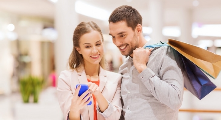 Couple looking at mobile phone while shopping