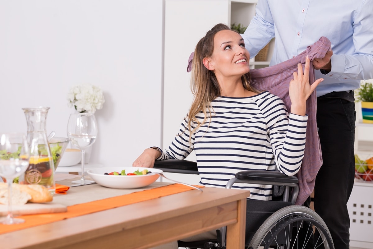 Disabled woman in wheelchair at kitchen table