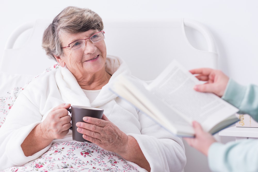 Elderly woman being read to in hospital
