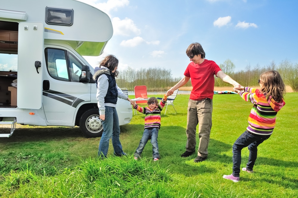 Family playing together outside their caravan