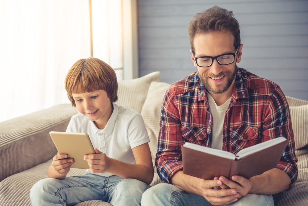 Adult male and boy reading together