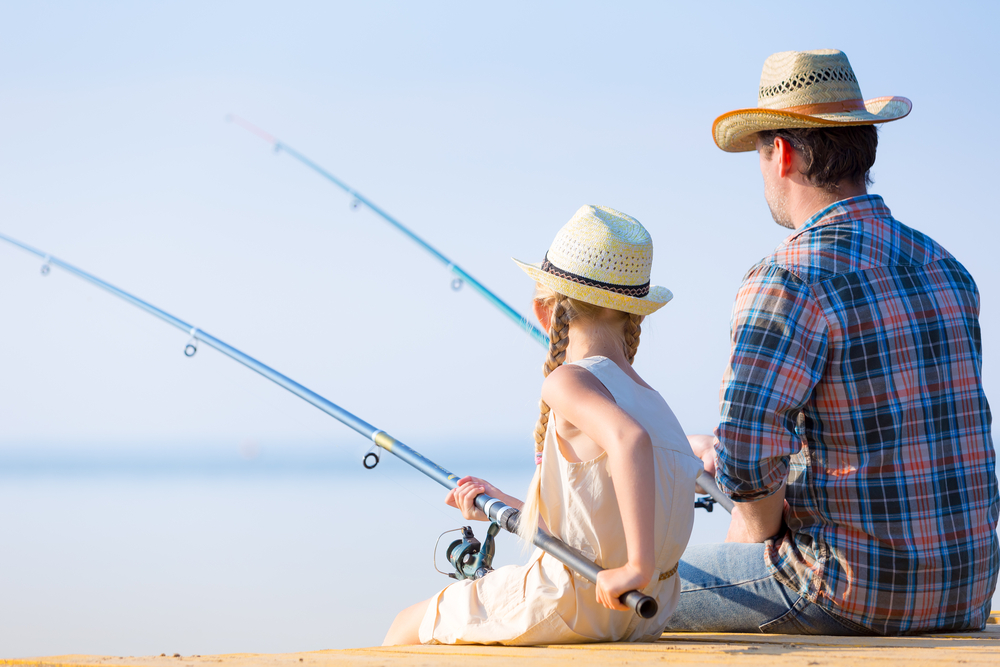 Father and daughter fishing on a dock