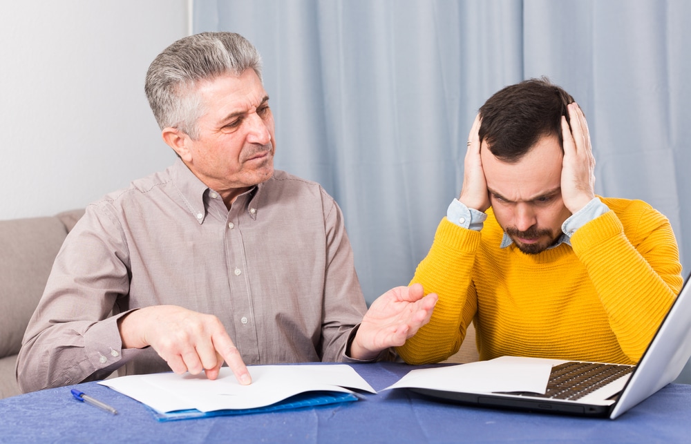 Father explaining a repayment plan to reluctant son