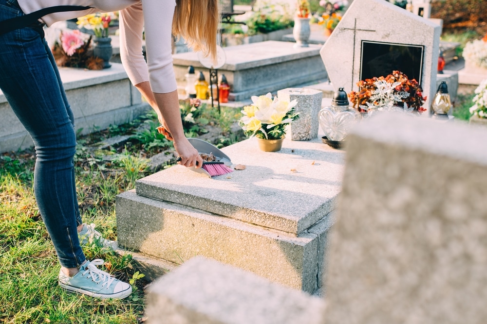 Woman cleaning gravestone