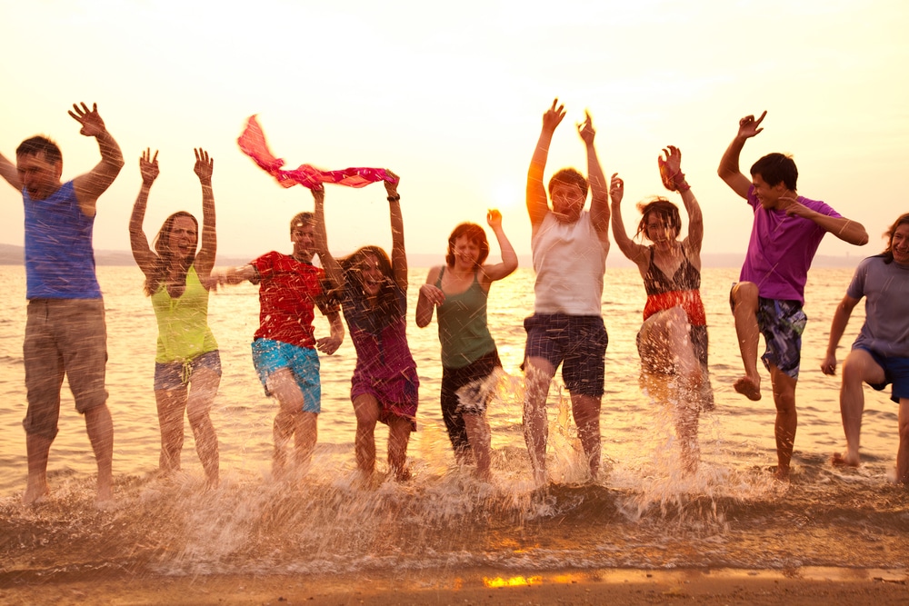 Group of young adults jumping happily in the sea