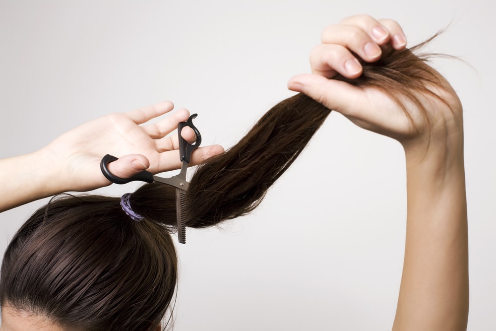 Woman cutting her ponytail off