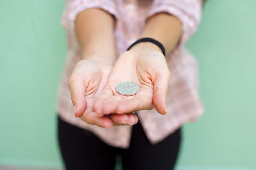 Woman holding out a coin