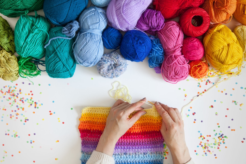 Woman knitting rainbow scarf