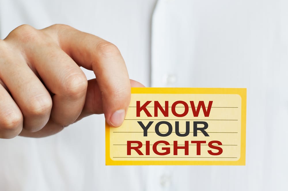 Someone holding a "know your rights" label
