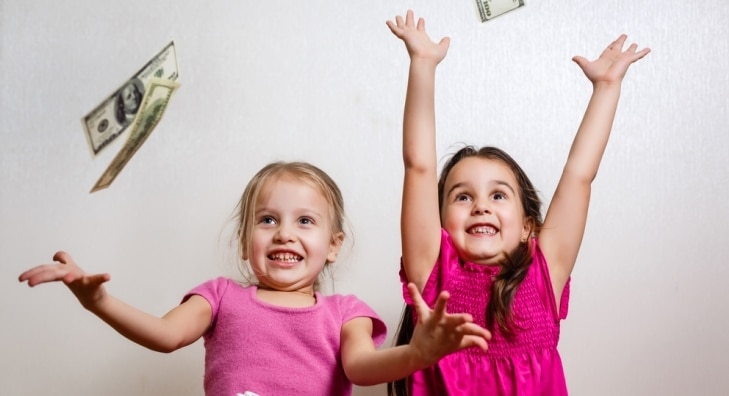Excited little girls catching raining money