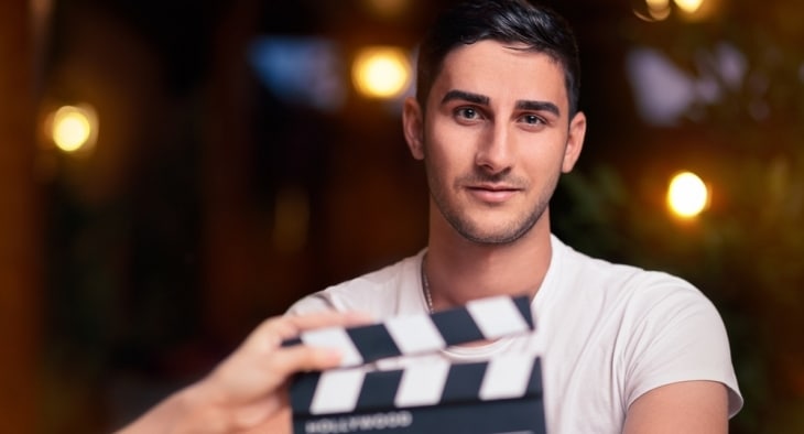 Male actor behind clapper board