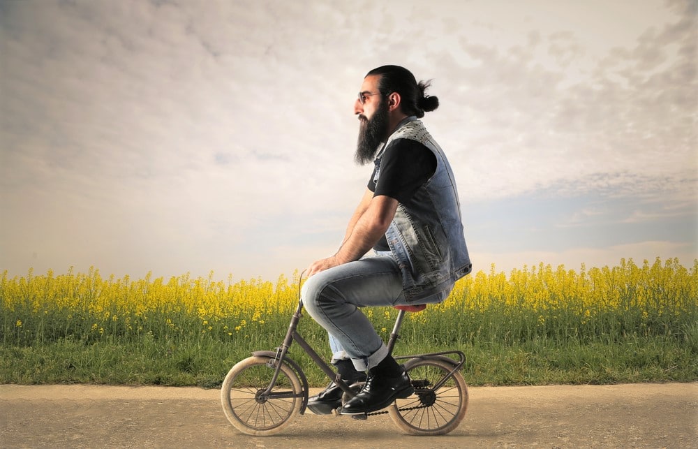 Large man riding very small bicycle