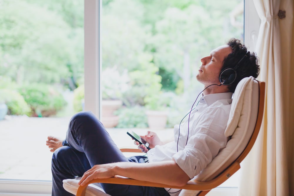 Man relaxing at home listening to music