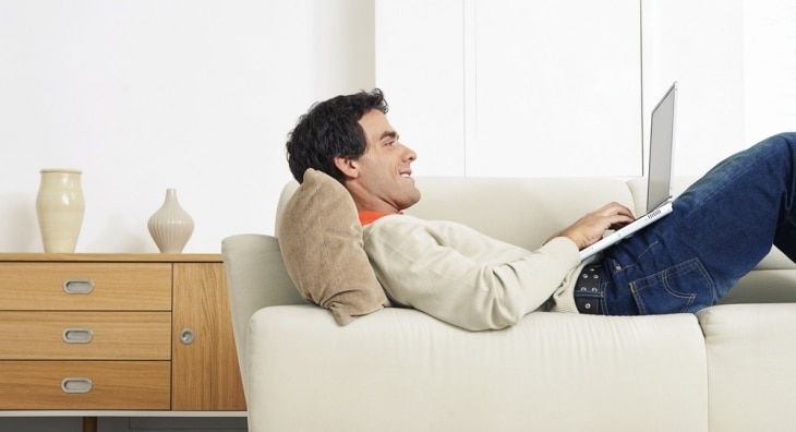 Man relaxing on the sofa with his laptop