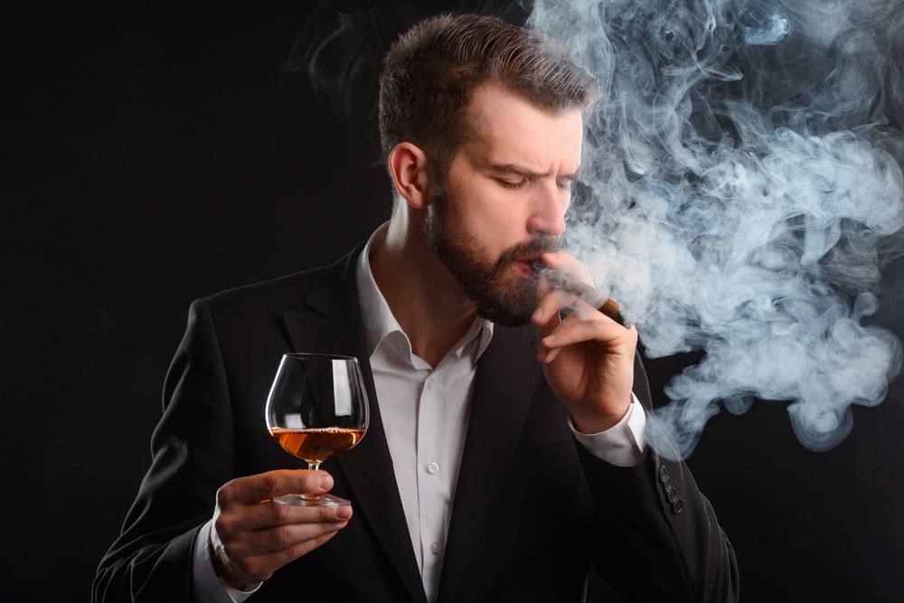 Man smoking and drinking hard liquor