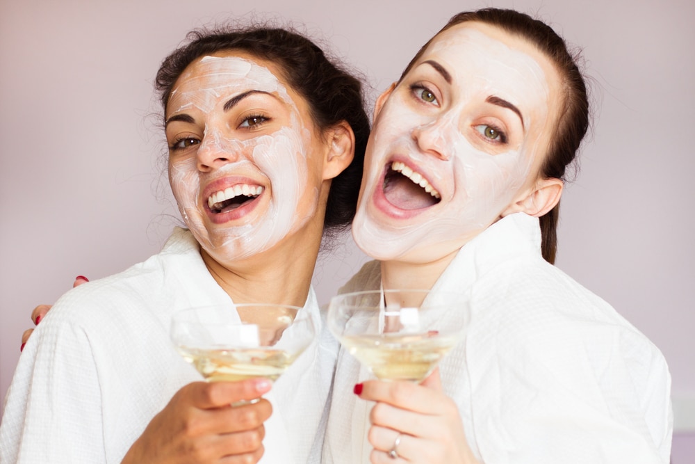 Friends wearing face masks and drinking champagne