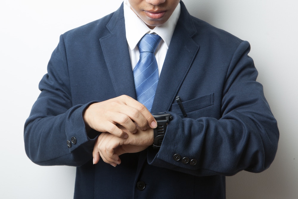 professional man in a suit looking at hi wrist watch