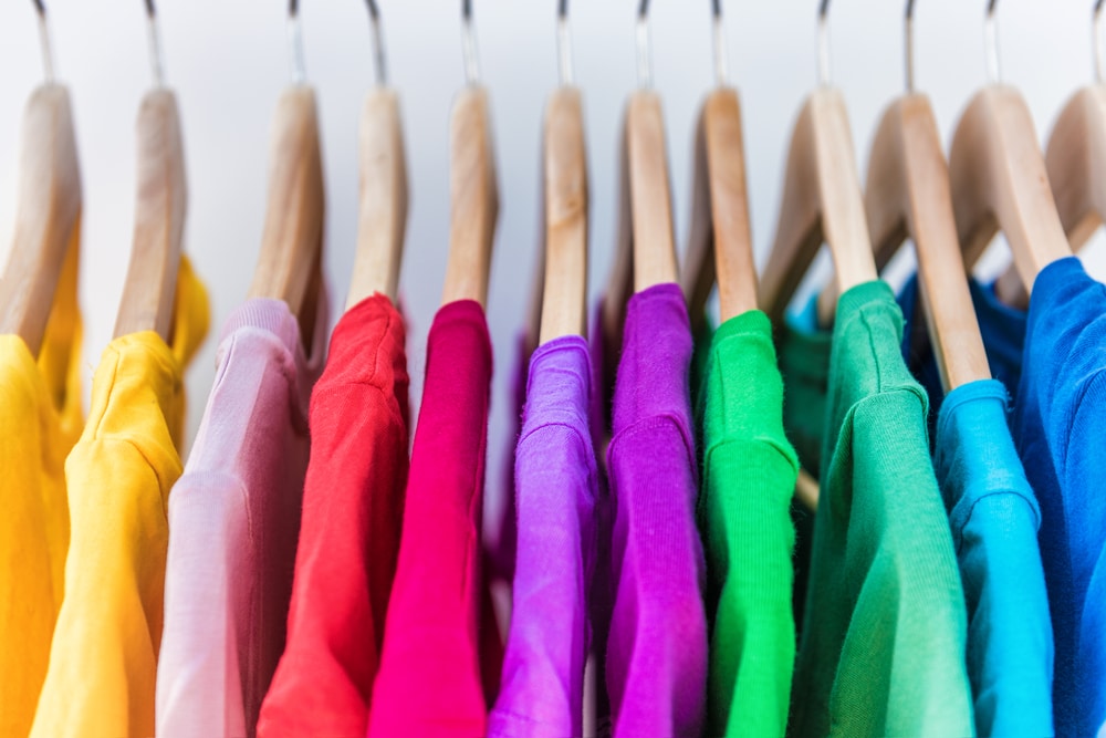 Rainbow coloured clothes on hangers
