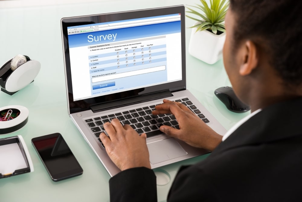 Business man completing online surveys on a laptop