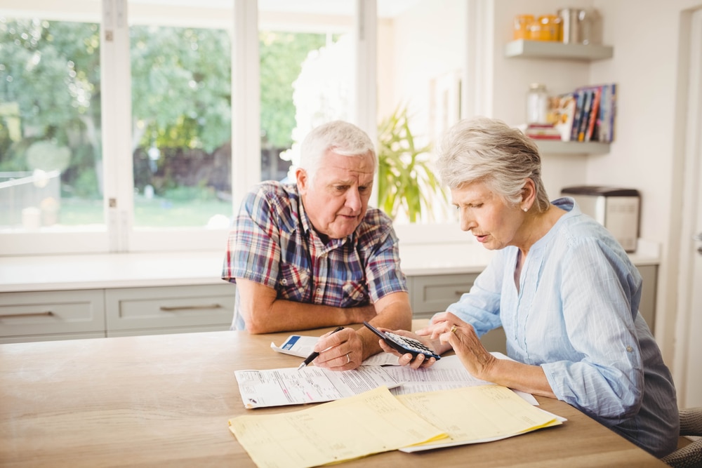 Older couple sat at the kitchen table doing financial planning