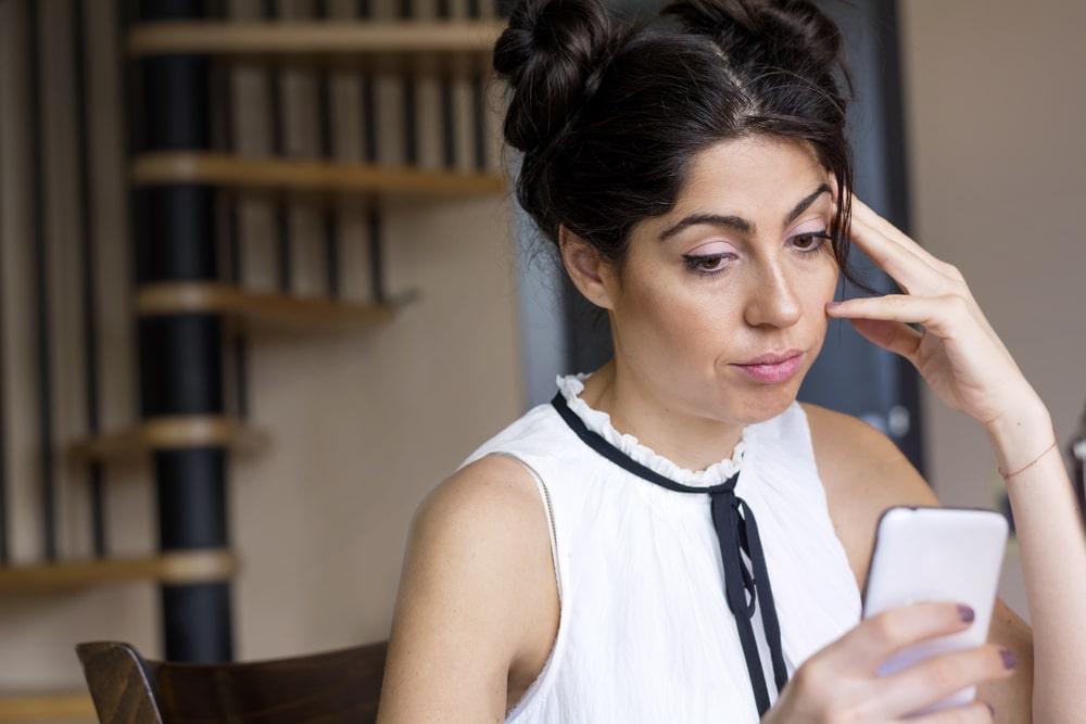 Stressed woman using mobile phone
