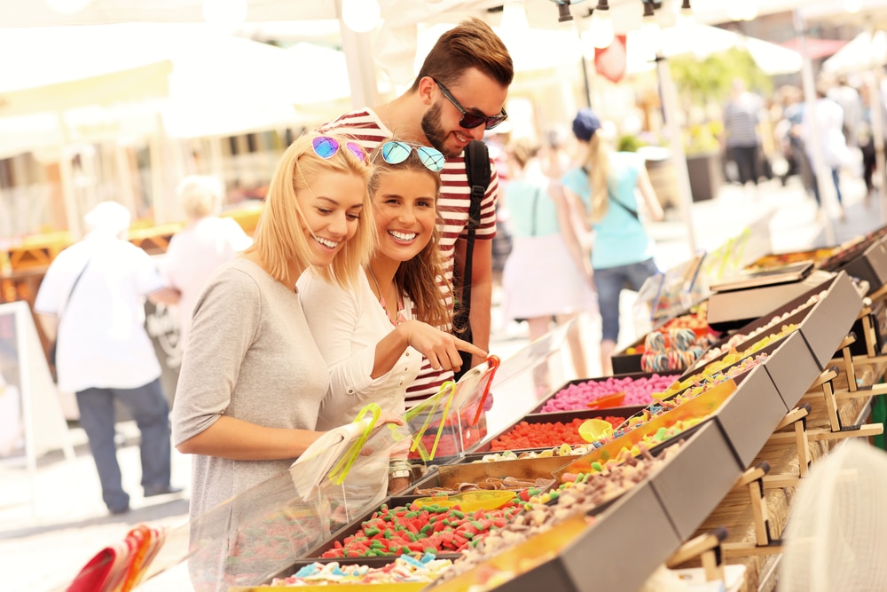 Young people buying sweets at a market stall