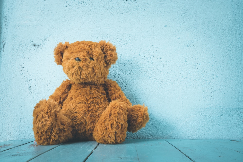 Brown teddy bear on blue background