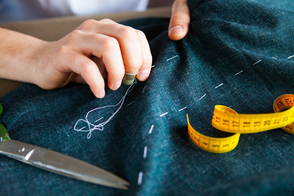 Tailor hand stitching fabric