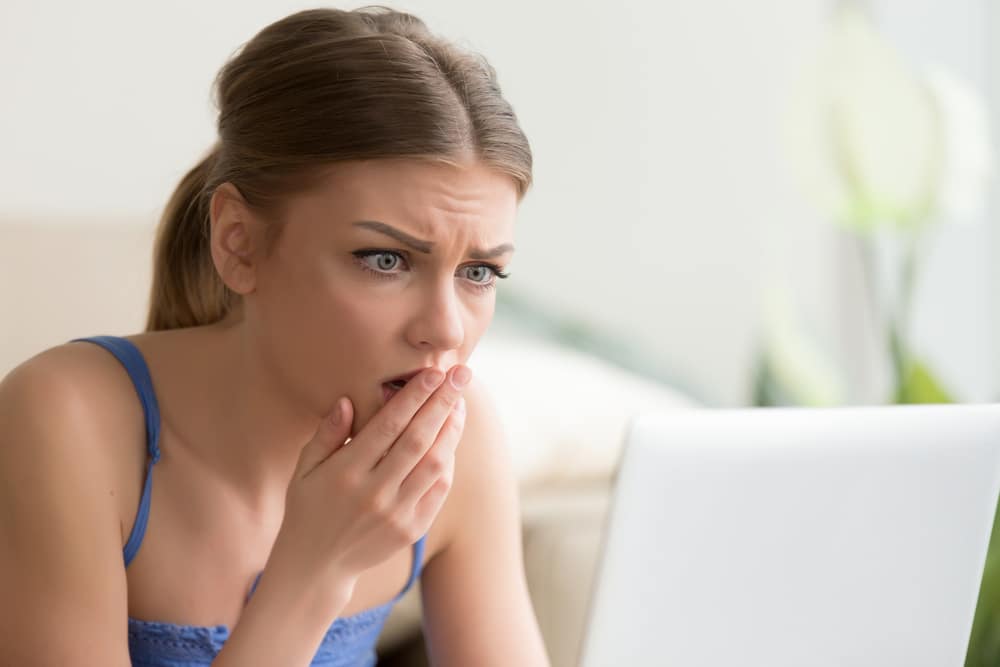 Shocked/Upset young woman looking at something on a laptop