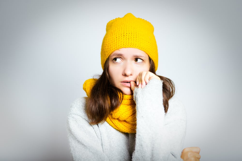 Woman in winter knits looking worried