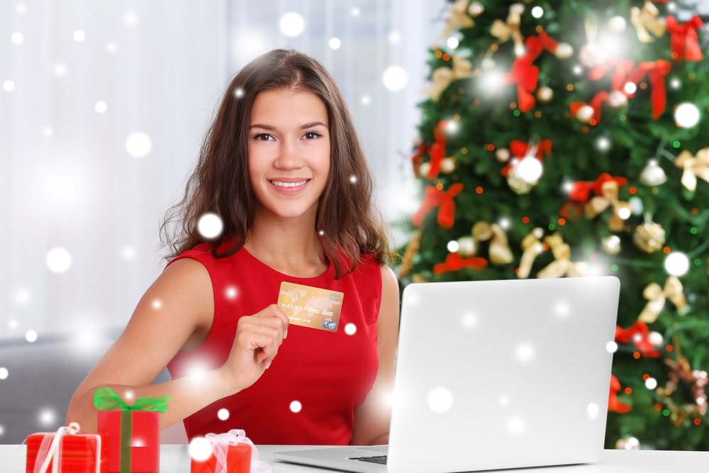 Festive woman shopping online with credit card
