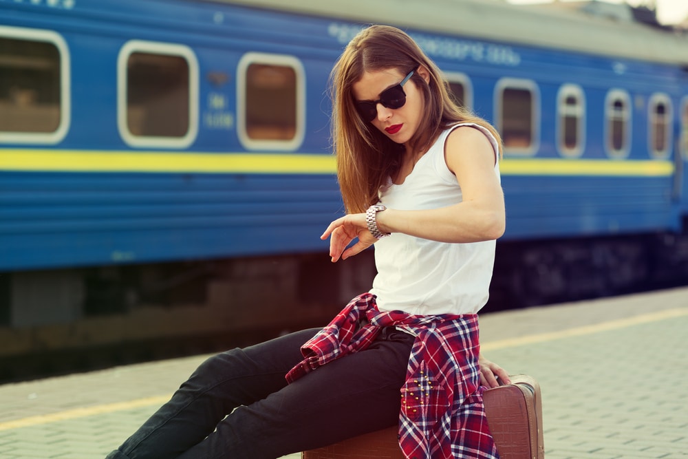 Woman looking at her watch waiting for a train