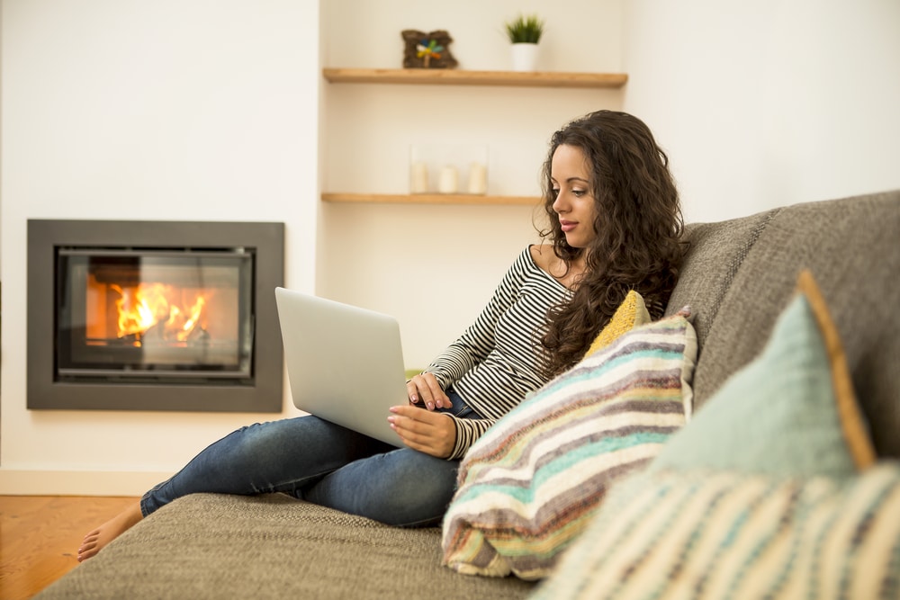 Woman sat on the sofa by a gas fire