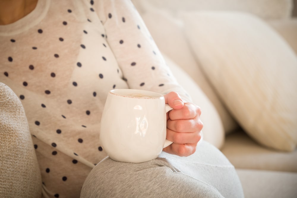 Woman relaxing on the sofa with a hot drink
