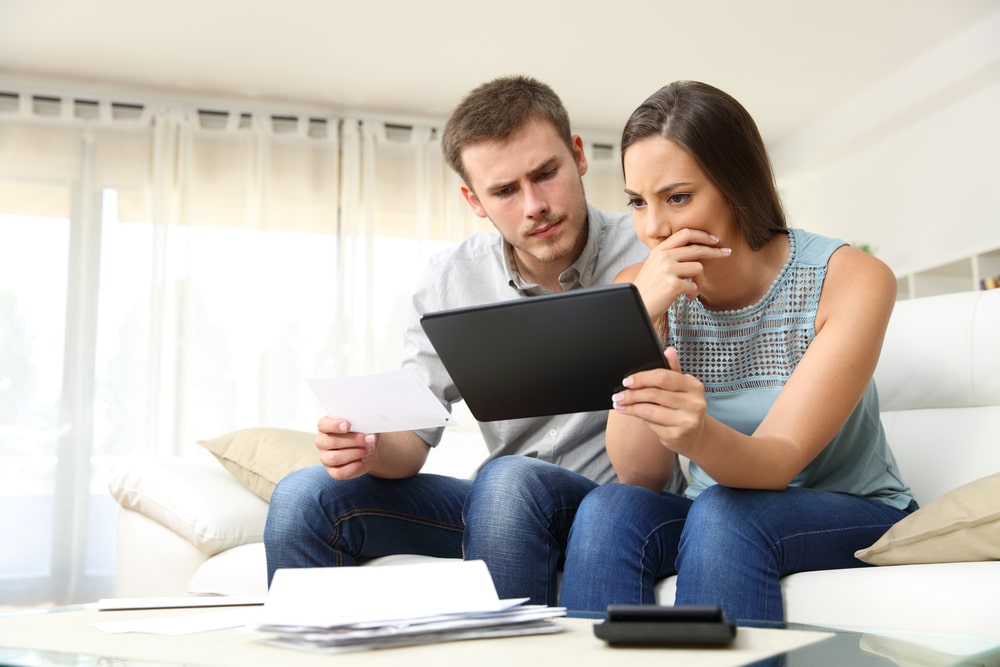 Worried couple looking at a tablet