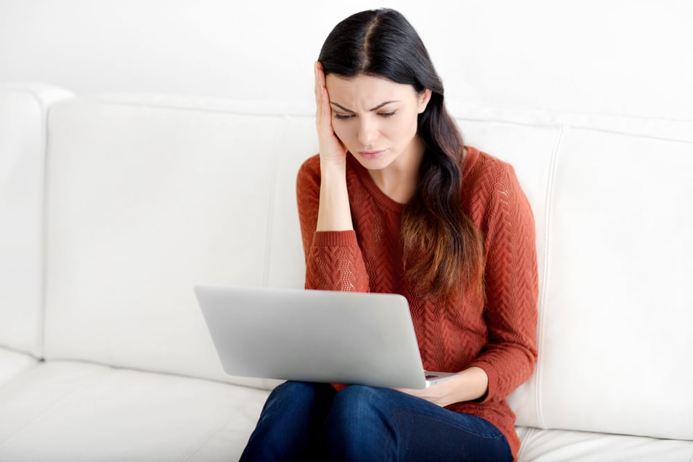 Worried woman looking at laptop