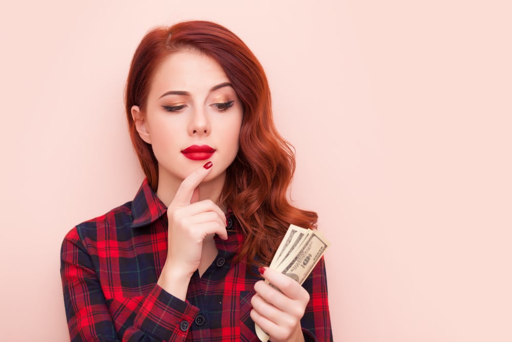 Woman looking at money thoughtfully