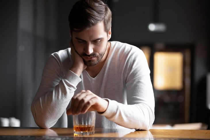 alcoholic man staring at whiskey