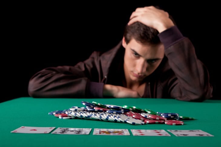 Man at casino table with gambling addiction
